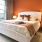 a bedroom with a large window and an orange wall