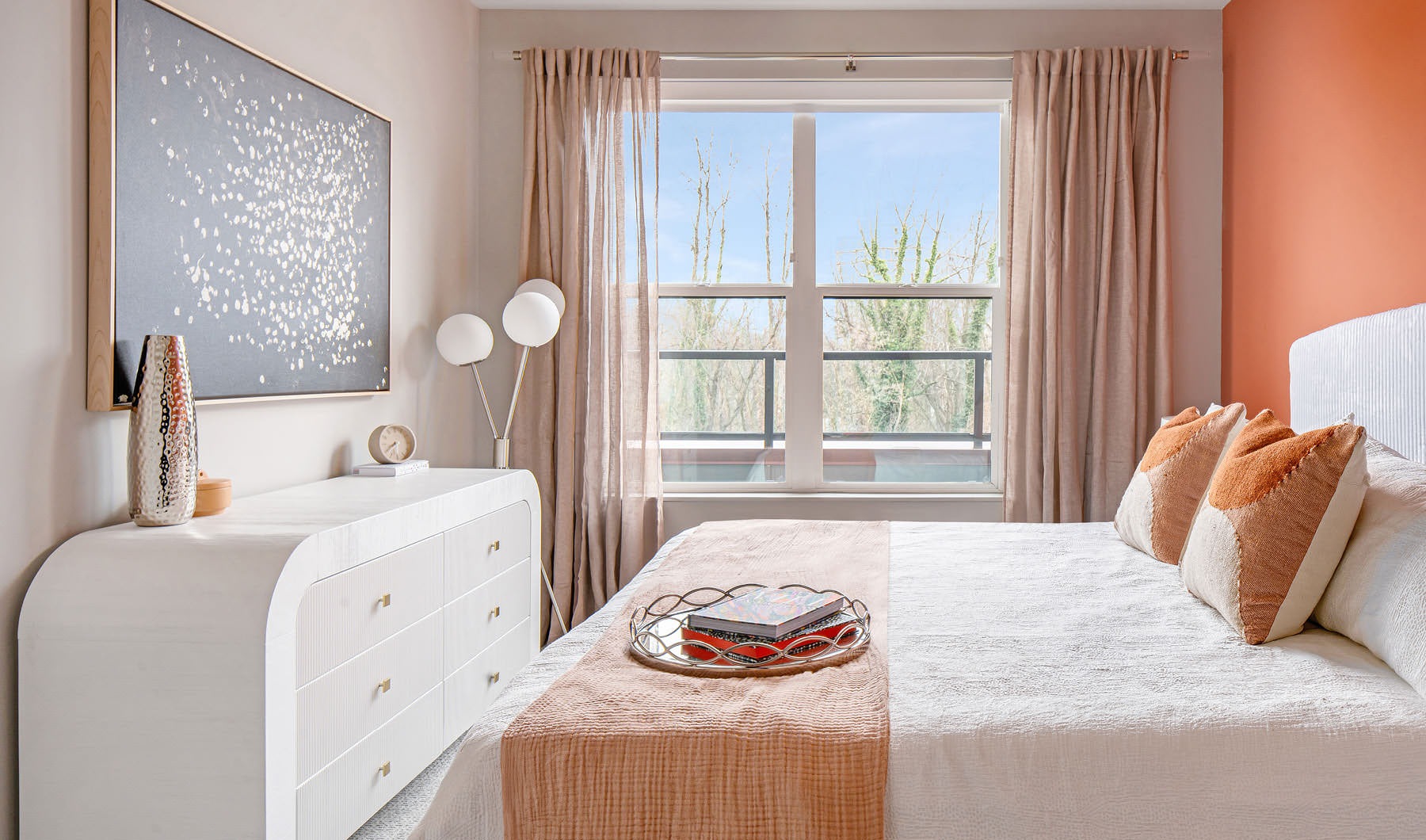 a bedroom with a large window and a white dresser